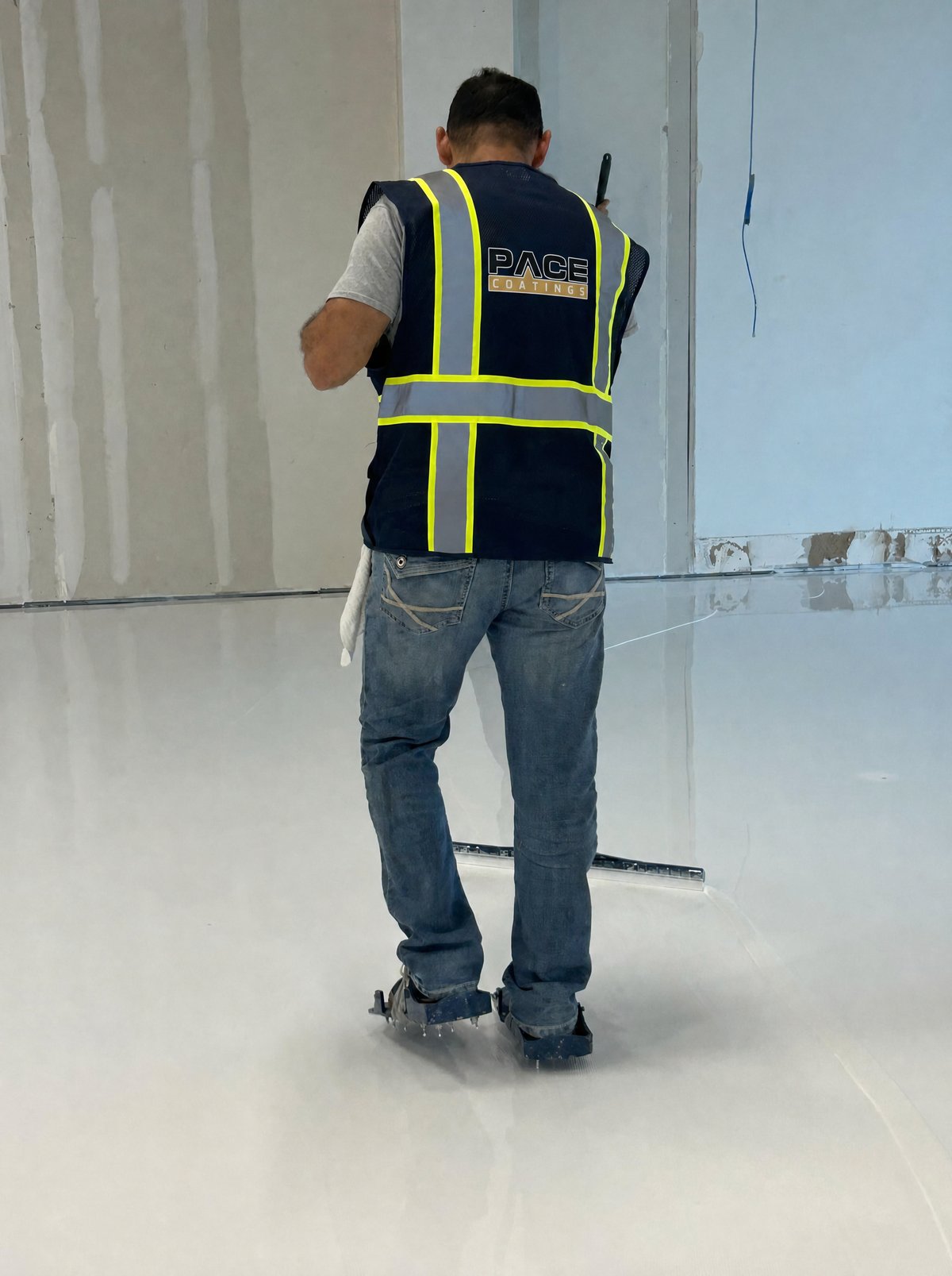 Pace Coatings technician applying an epoxy floor coating, Houston TX